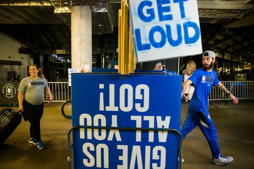 Mavs employees remove signs from the court after the Dallas Mavericks beat the Denver...