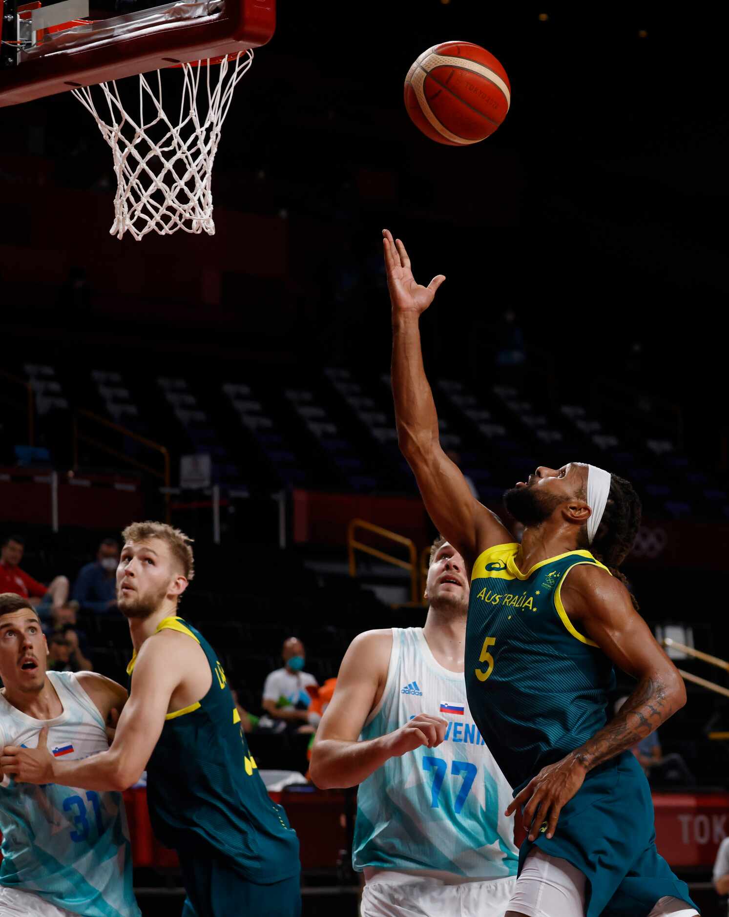 Australia’s Patty Mills (5) attempts a layup in front of Slovenia’s Luka Doncic (77) during...