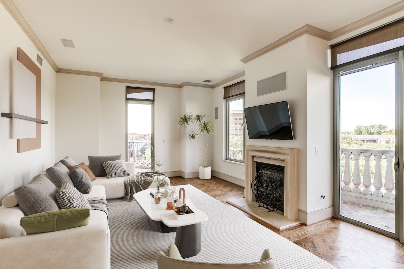 A living room has windows that look to Turtle Creek and the building's pool.