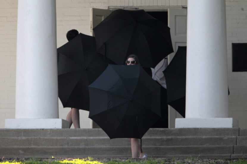 Staff members use umbrellas to hide Candice Crawford moments before her wedding ceremony at...
