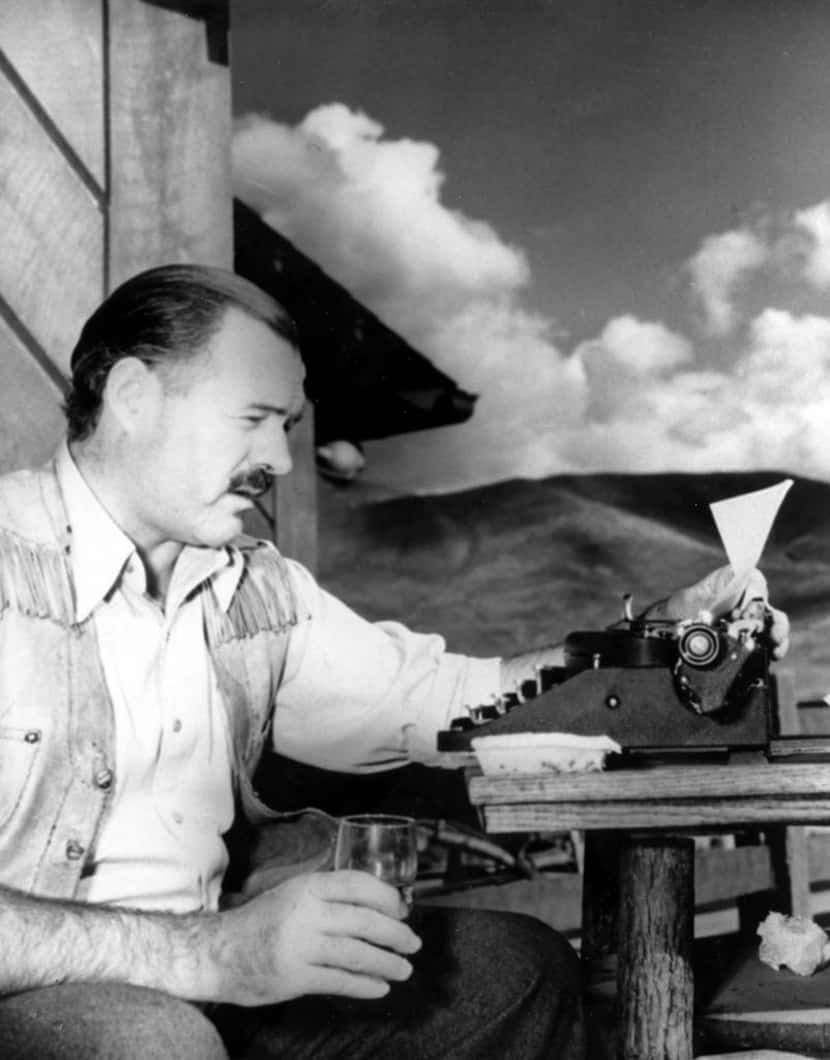 American novelist and short-story writer Ernest Hemingway at his typewriter as he works at...