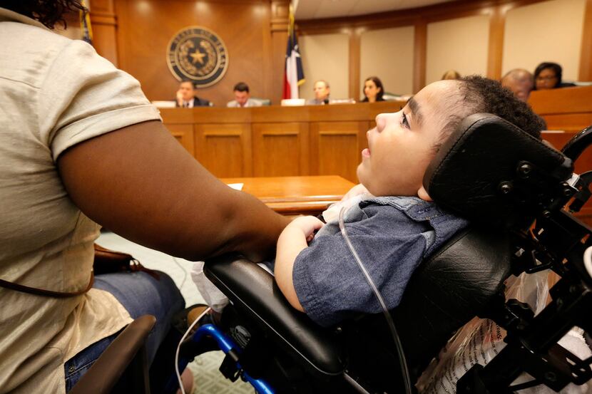 Three-year-old D'ashon Morris sits alongside his mother, Linda Badawo of Mesquite, as she...