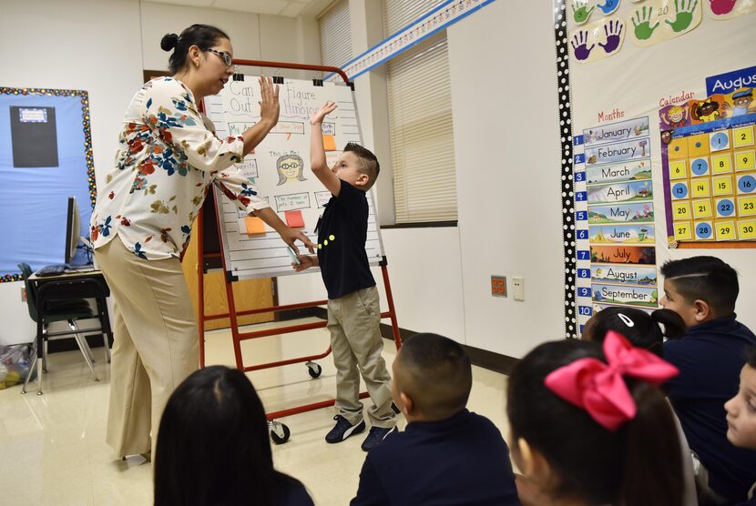 Annette Hinojosa, maestra de primer grado, felicita a su estudiante Isaac Martínez durante...