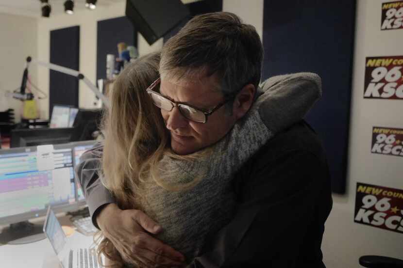 Former KSCS cast member Rebecca Carrell hugs radio personality Mark "Hawkeye" Louis after...