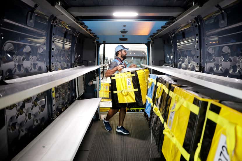 Delivery associate Ali Haider loads totes into his Electronic Delivery Vehicle (EDV) at one...