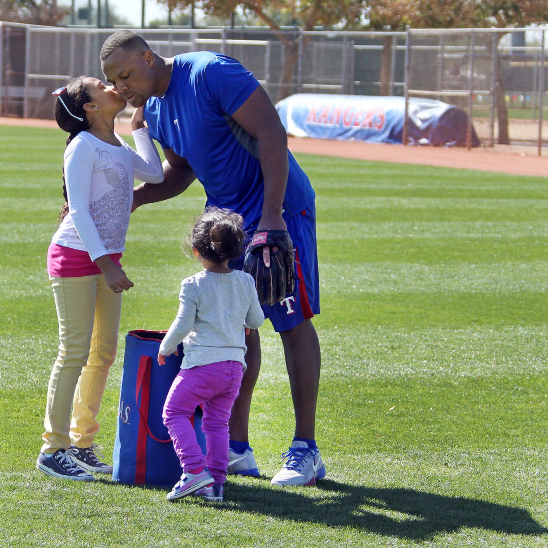 Texas Rangers third baseman Adrian Beltre gets a kiss from daughter Cassie, 9, left, as...