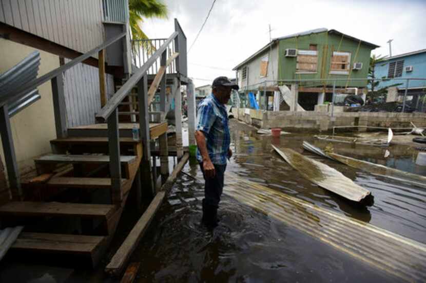 Héctor Rosa atraviesa una zona inundada tras el paso dle huracán María en Juana Matos,...