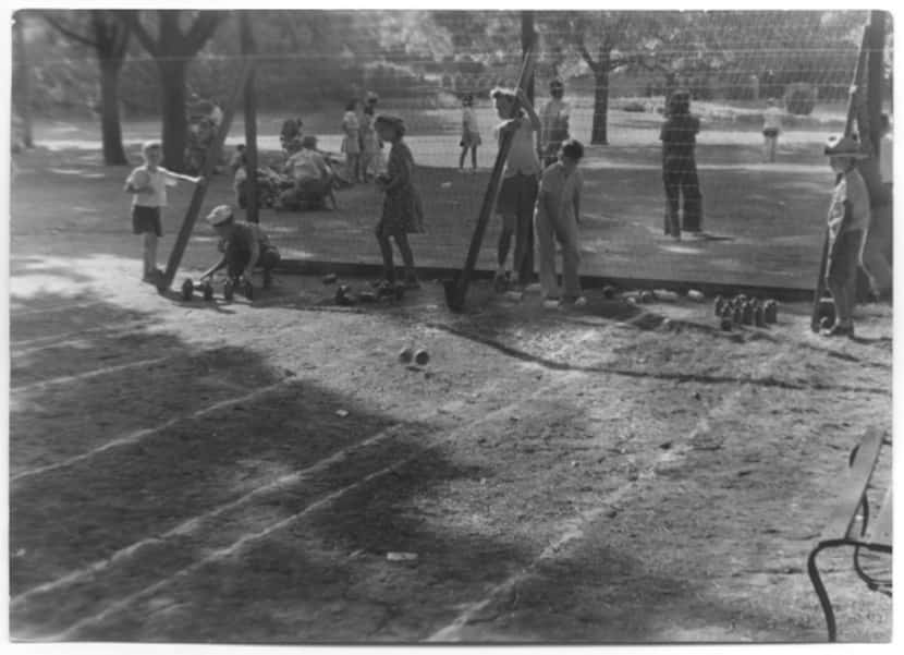 Young children use milk bottles and baseballs to bowl at Reverchon Park in 1943.