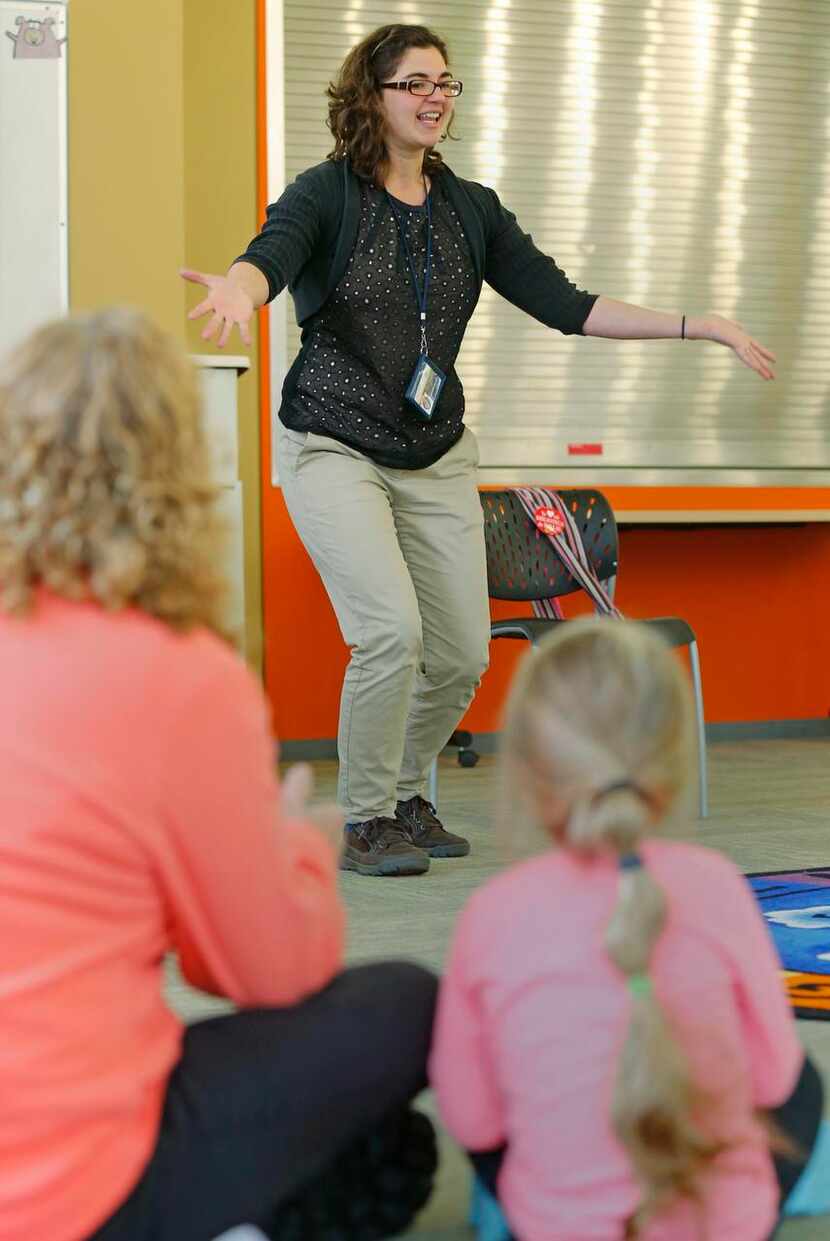 
Jenna Yoder (center) tells stories to Nova Nelson, 3, (right) and her nanny, Cindy...