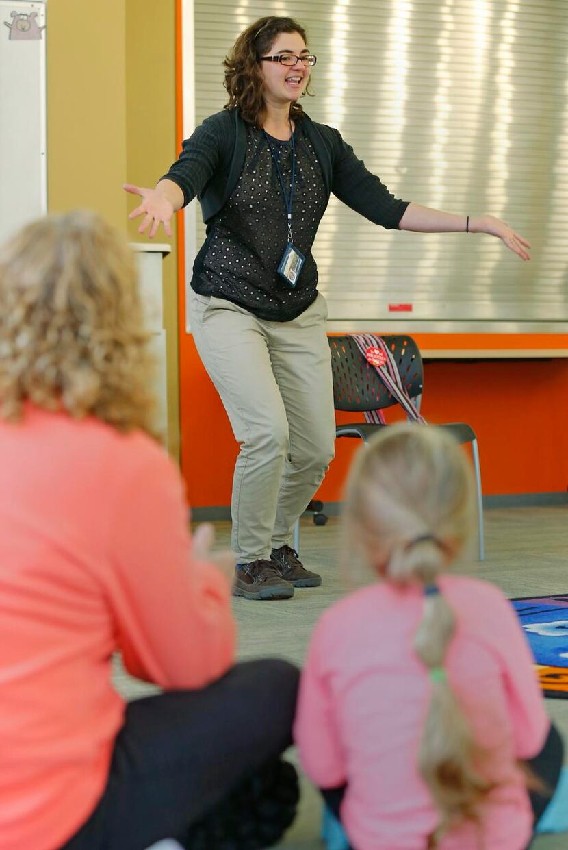 
Jenna Yoder (center) tells stories to Nova Nelson, 3, (right) and her nanny, Cindy...