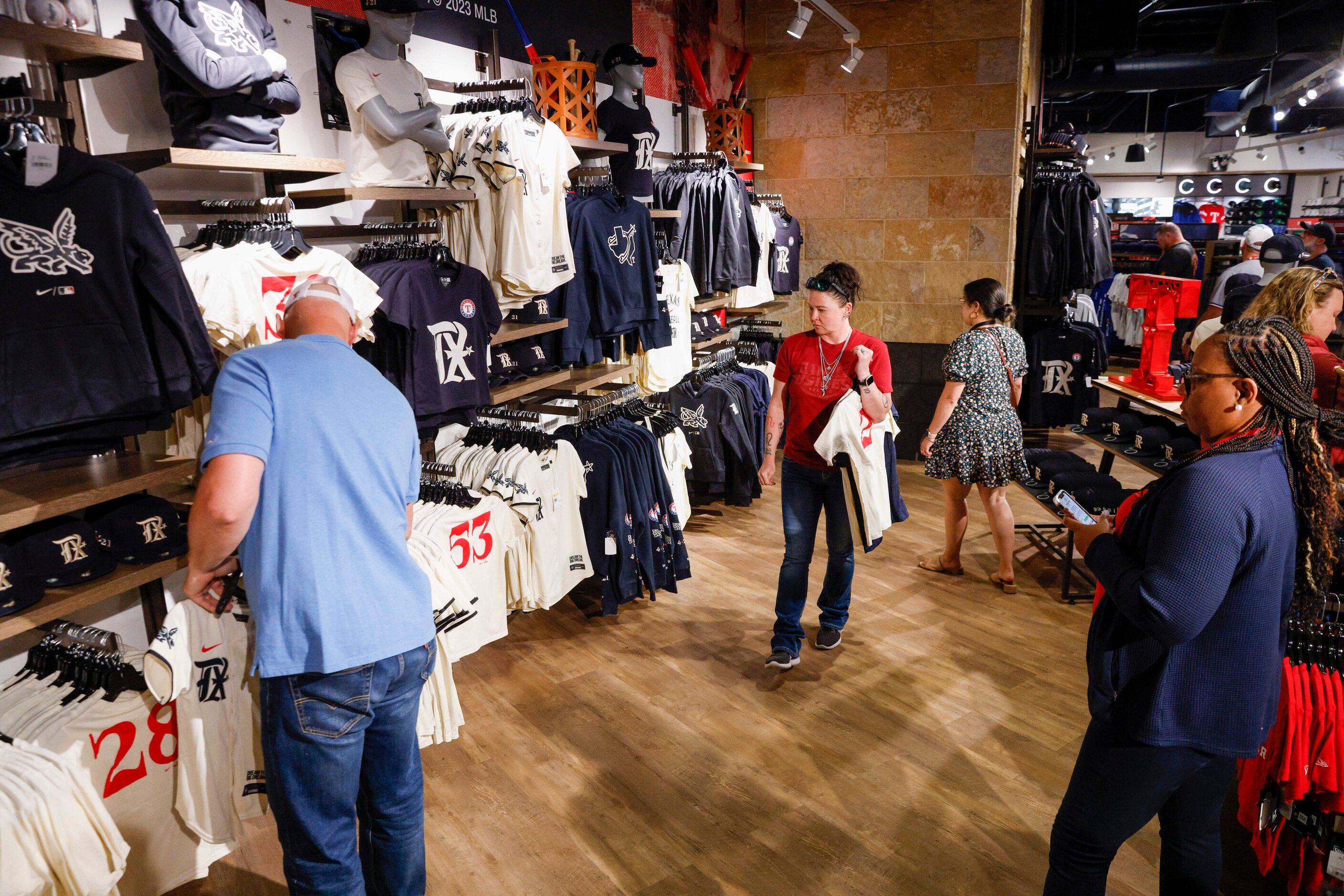 Fans browse the new Texas Rangers City Connect merchandise at Globe Life Field on Monday,...