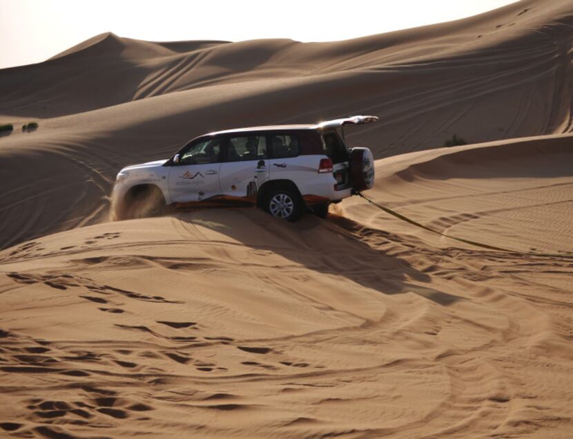 Getting stuck in the sand is half the fun. A second Land Cruiser pulls this guy out from a...