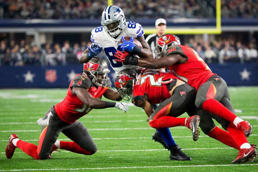 Dallas Cowboys wide receiver Dez Bryant (88) is brought down by three defenders during the...