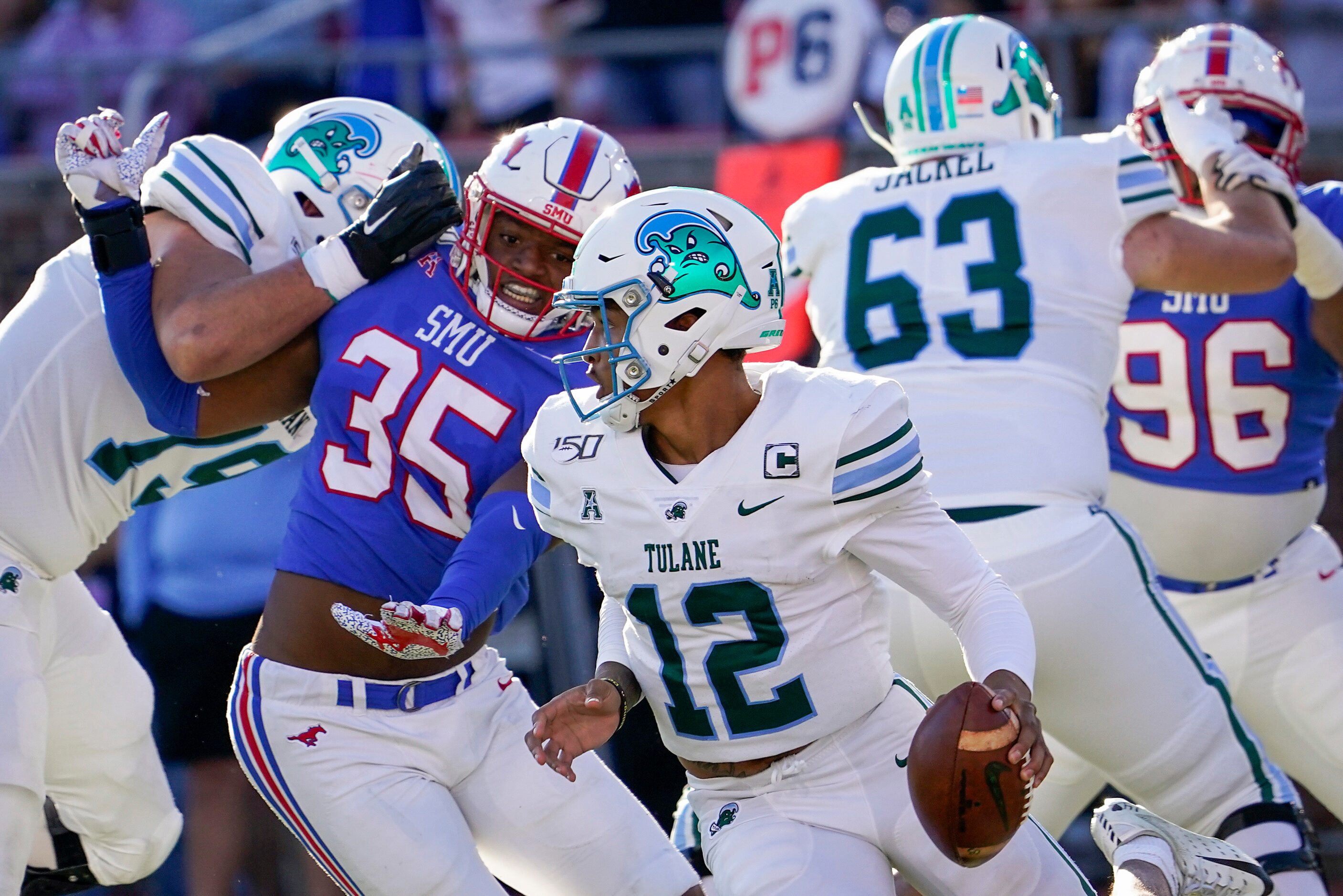 Tulane quarterback Justin McMillan (12) scrambles away from SMU defensive end Delontae Scott...