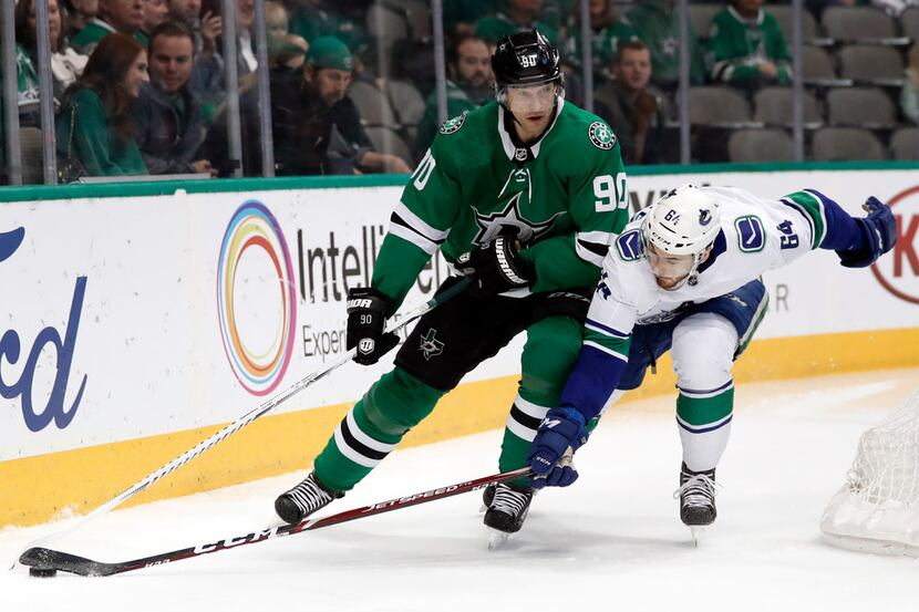 Dallas Stars center Jason Spezza (90) works to keep control of the puck under pressure from...