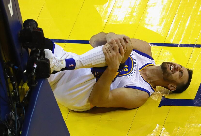 OAKLAND, CA - JUNE 13:  Andrew Bogut #12 of the Golden State Warriors reacts after suffering...