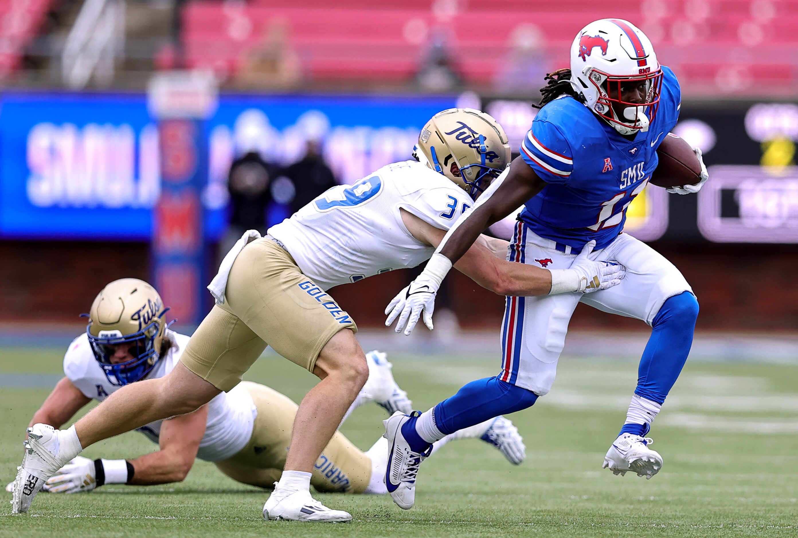 SMU running back LJ Johnson Jr (11) fights his way for yardage against Tulsa safety Dayne...