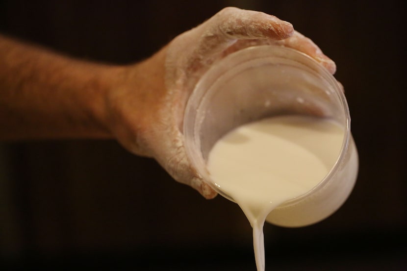 Chef Robert Lyford add milk while preparing cheddar biscuits at Patina Green Home and Market...