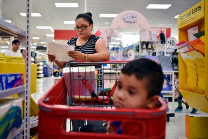 Rosa Moreno, de 28 años, revisa una lista mientras compra útiles escolares para el regreso a...