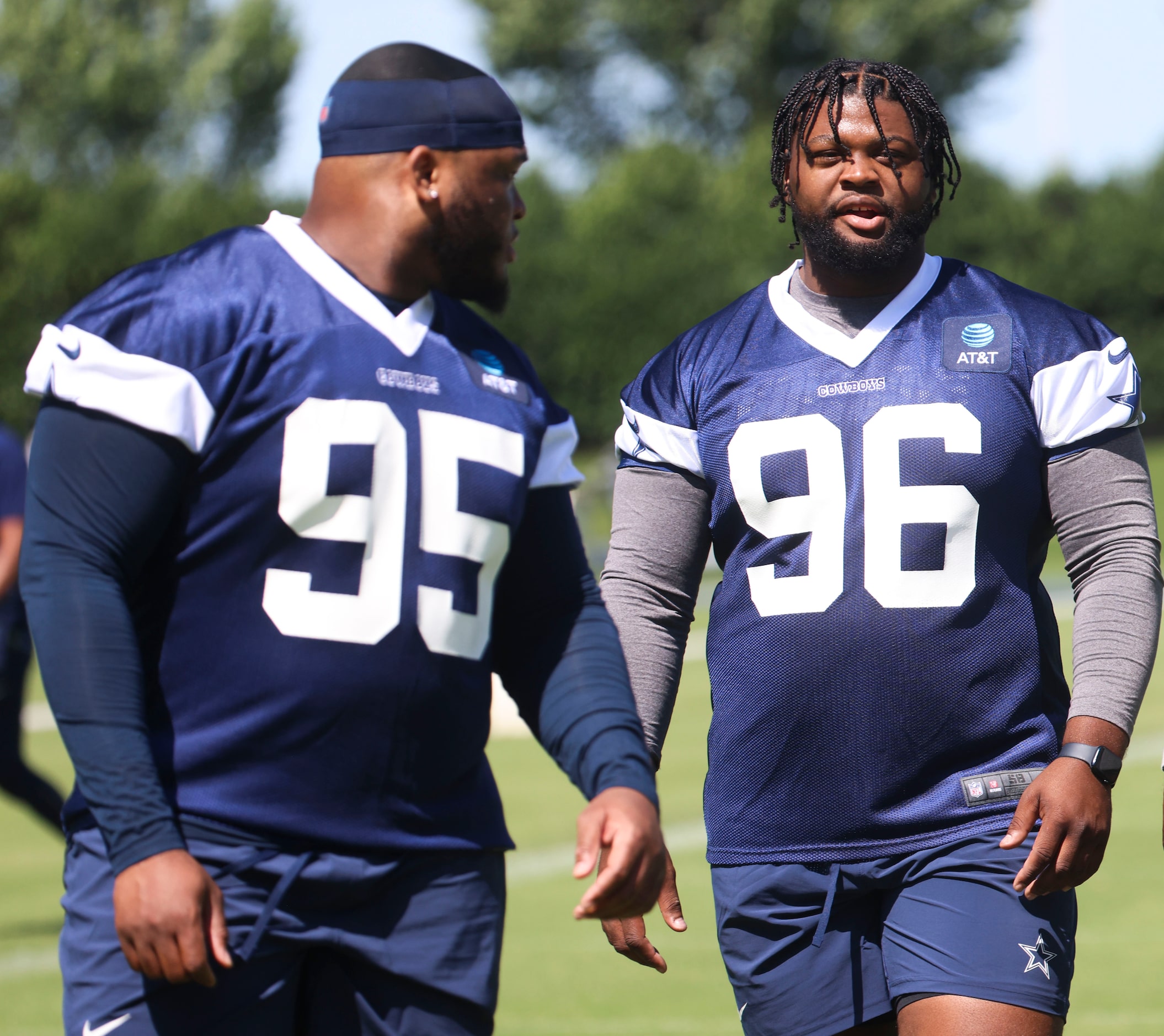 Dallas Cowboys defensive tackle Denzel Daxon (95) and Justin Rogers (96) exit the field...