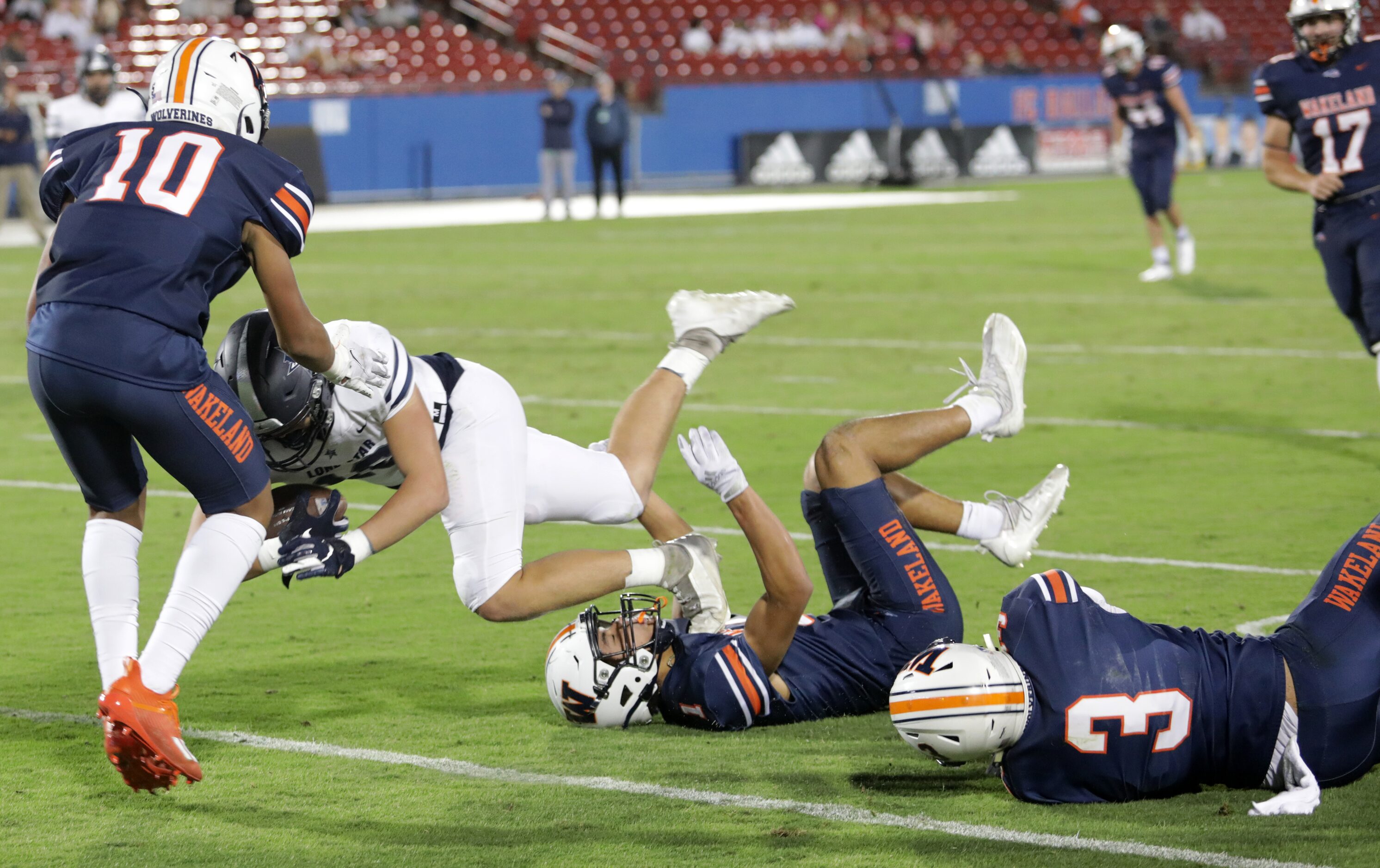 Wakeland player #10, Donovan Woolen, blocks Lone Star player #18, Evan Stein, as he steps...