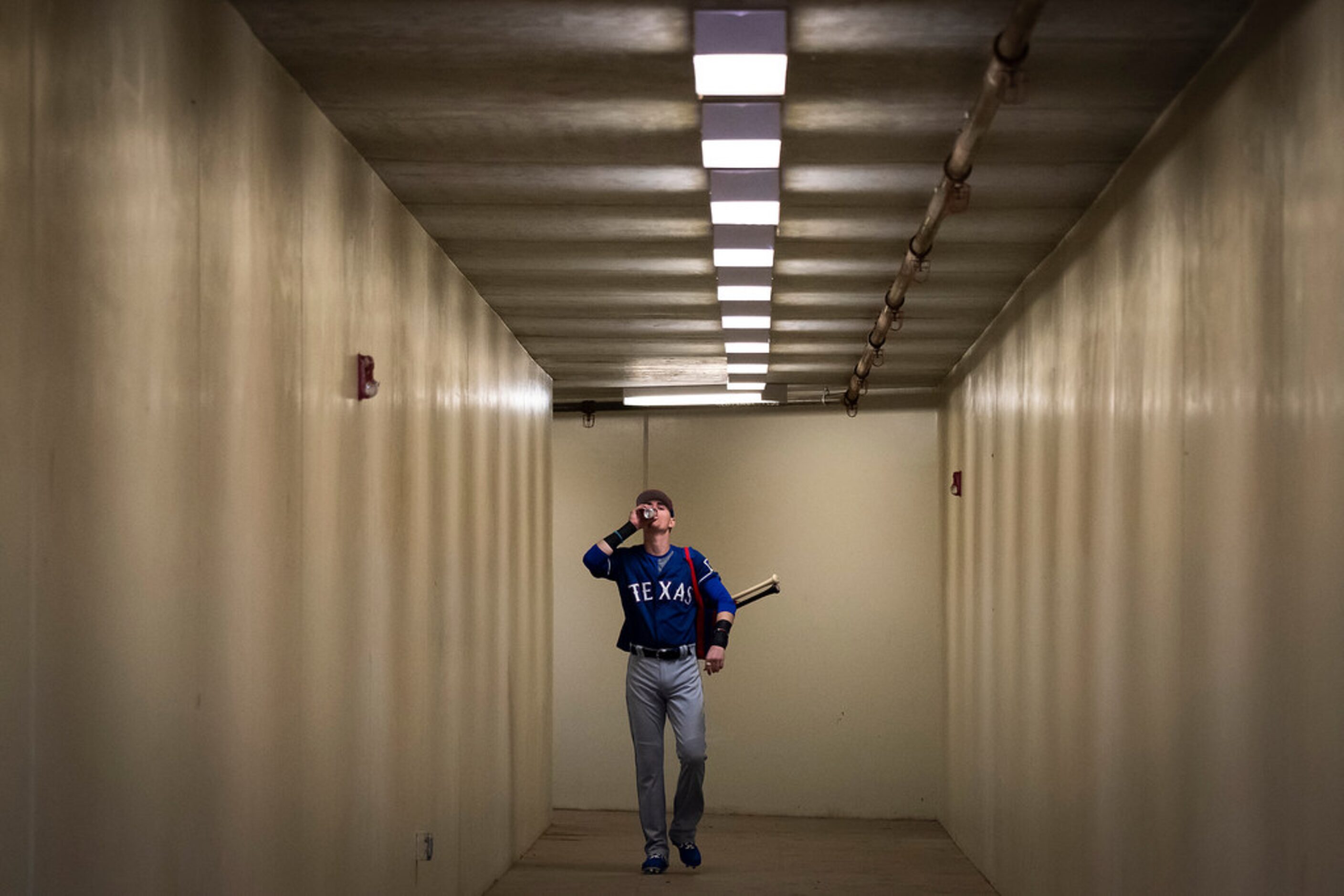 Texas Rangers outfielder Carlos Tocci drinks an energy drink as he walks from the clubhouse...