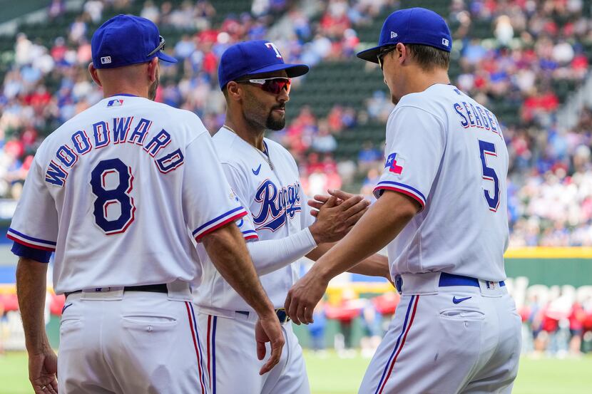 Texas Rangers shortstop Corey Seager shakes hands with second baseman Marcus Semien and...