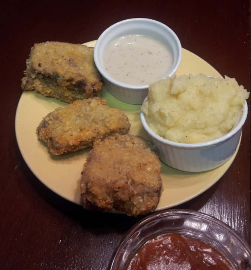 Southern Style Chicken-Fried Meatloaf is served with garlic mashed potatoes, cream gravy and...