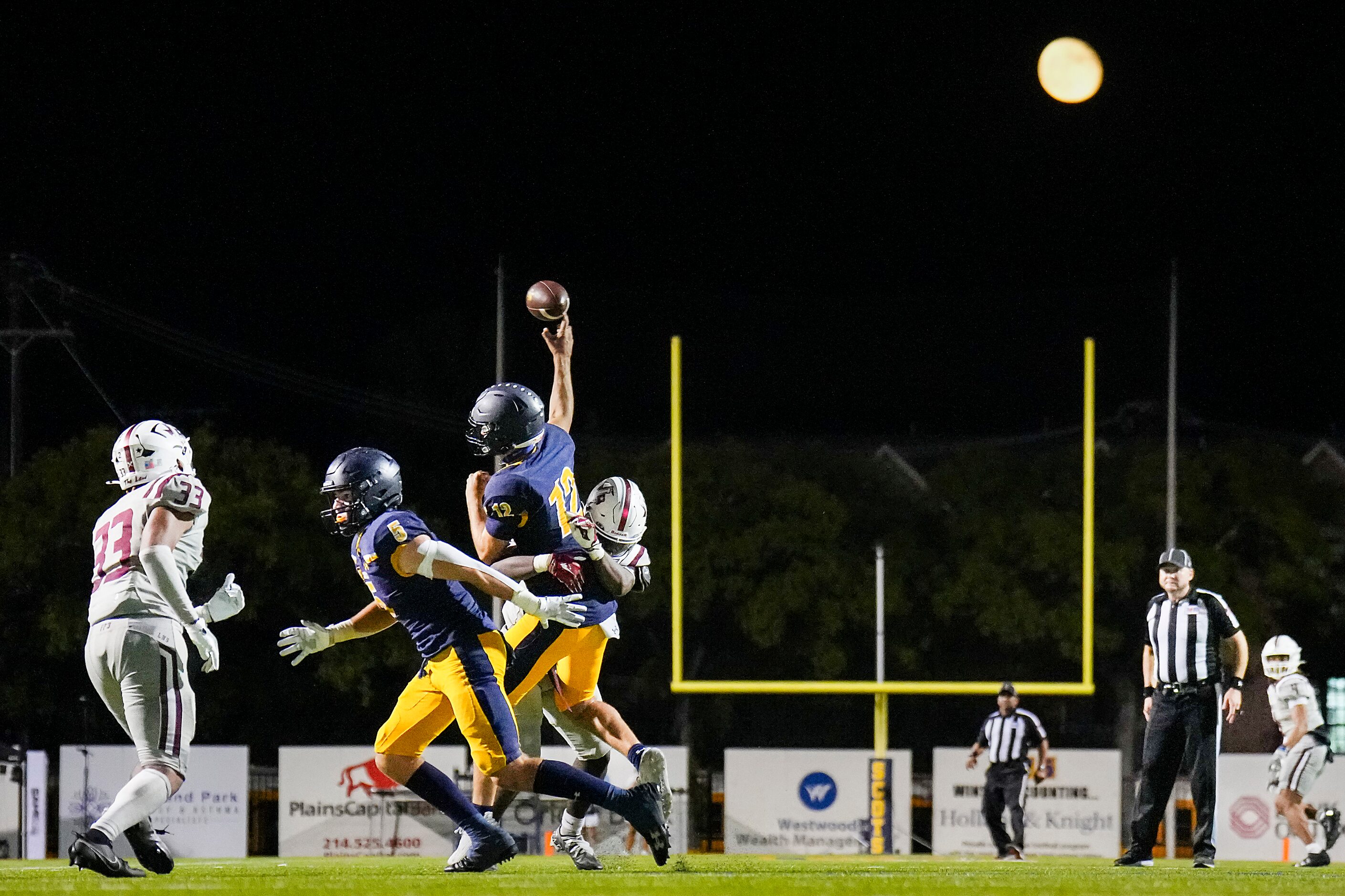 Highland Park quarterback Warren Peck (12) gets off a pass during the second half of a high...