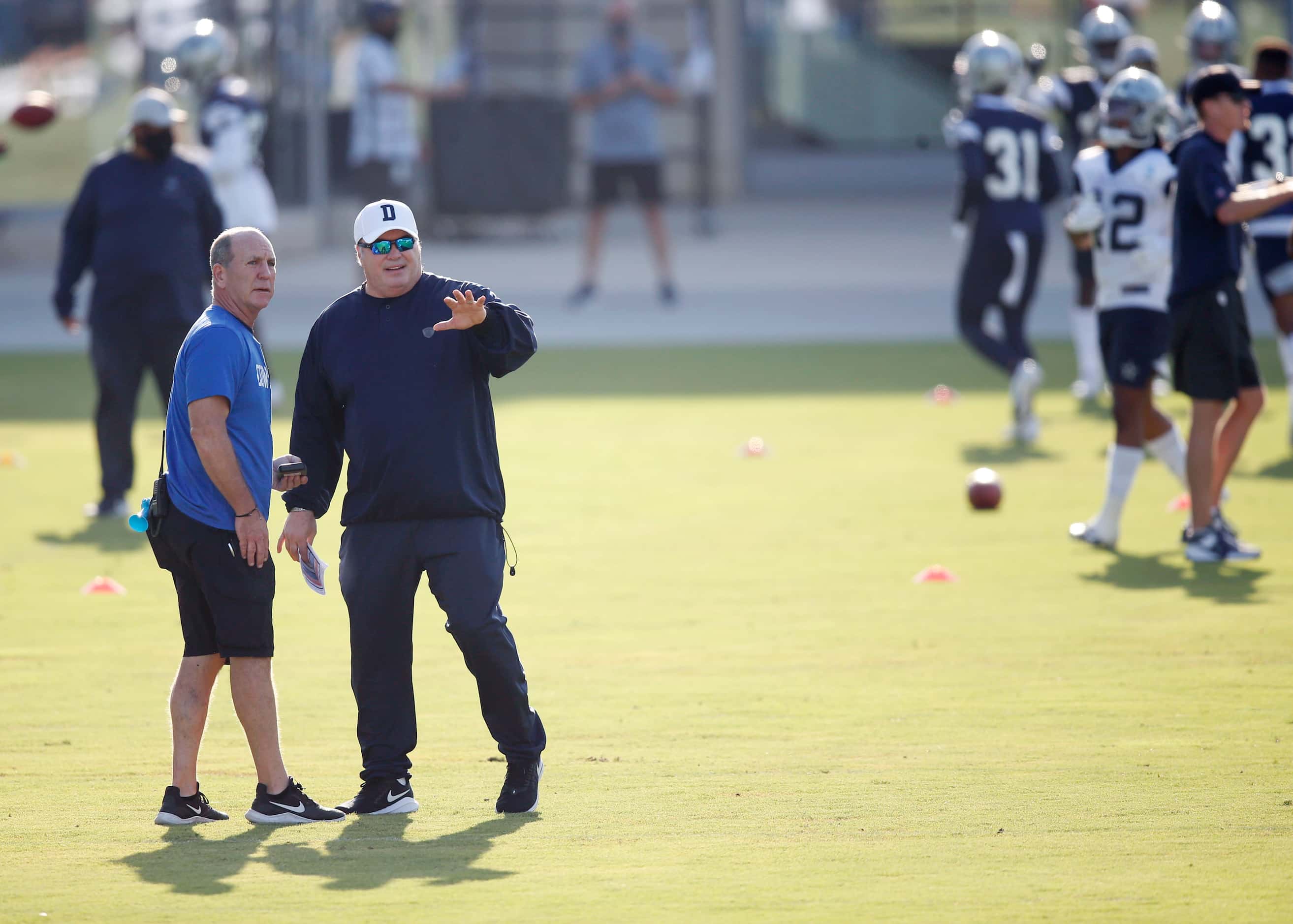 Dallas Cowboys head coach Mike McCarthy talks with Dallas Cowboys equipment coordinator...