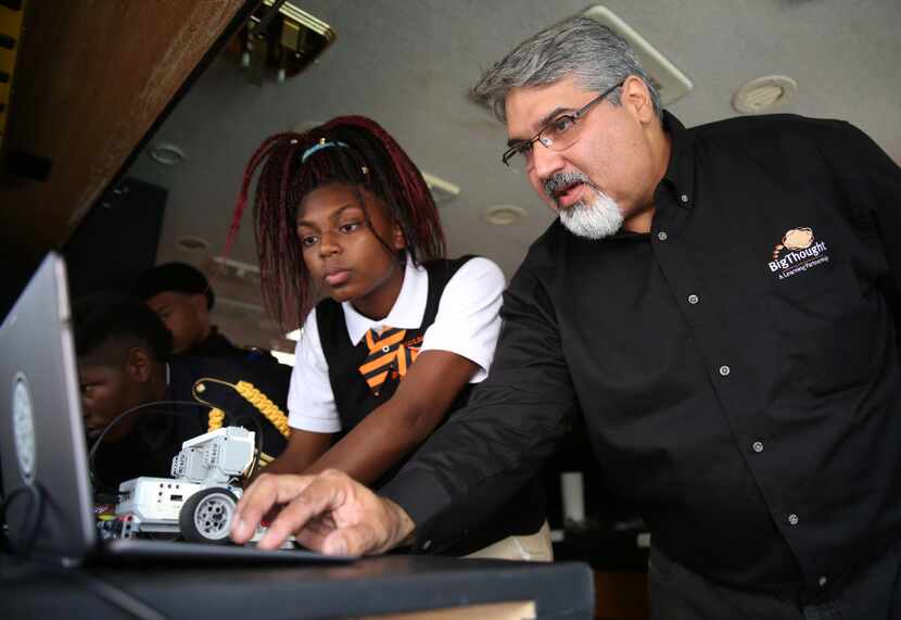 Karim Virani, director of technology for Big Thought helps eighth-grader India Anderson at...