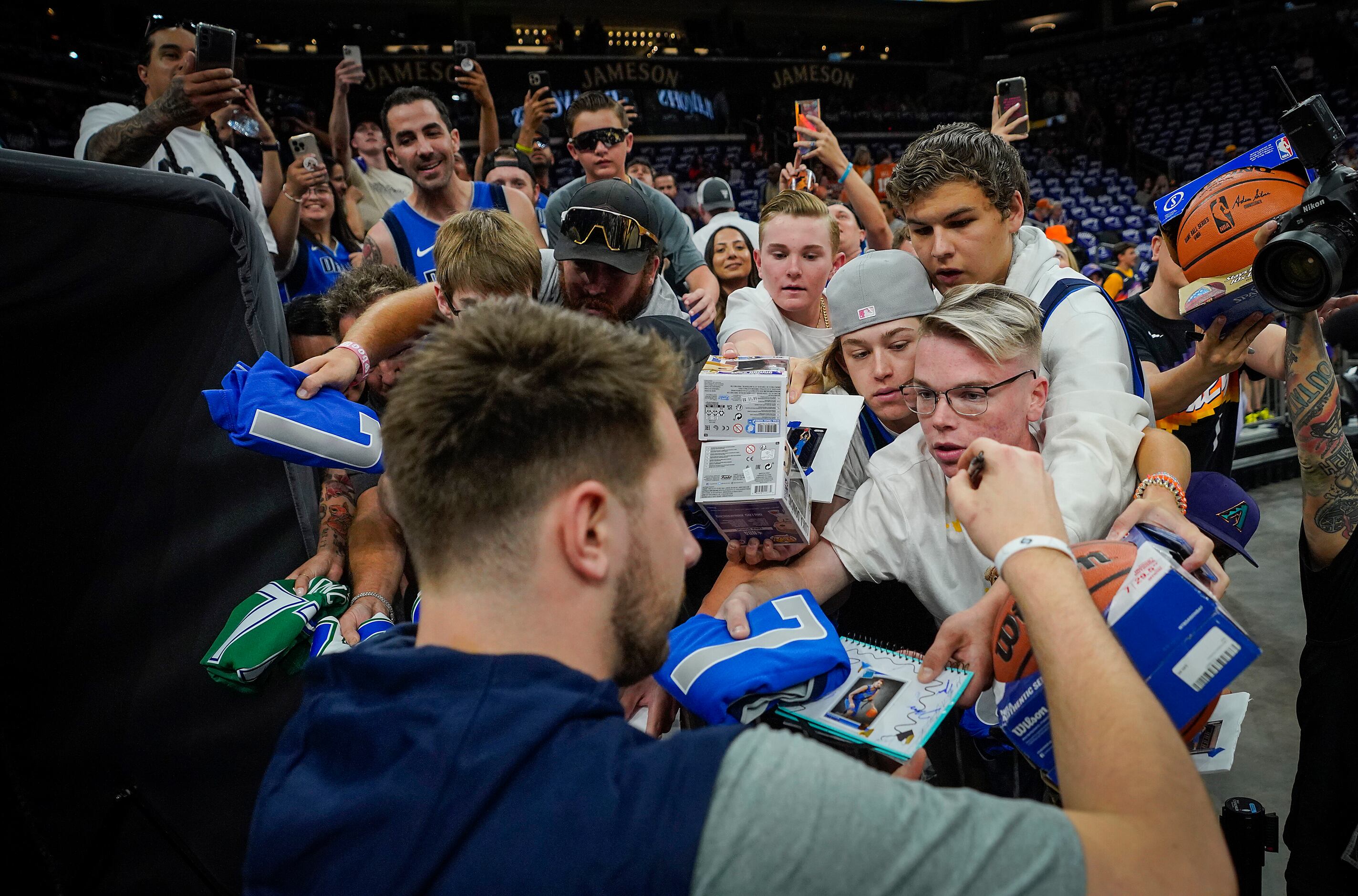 Dallas Mavericks guard Luka Doncic signs autographs for fans before Game 7 of an NBA second...