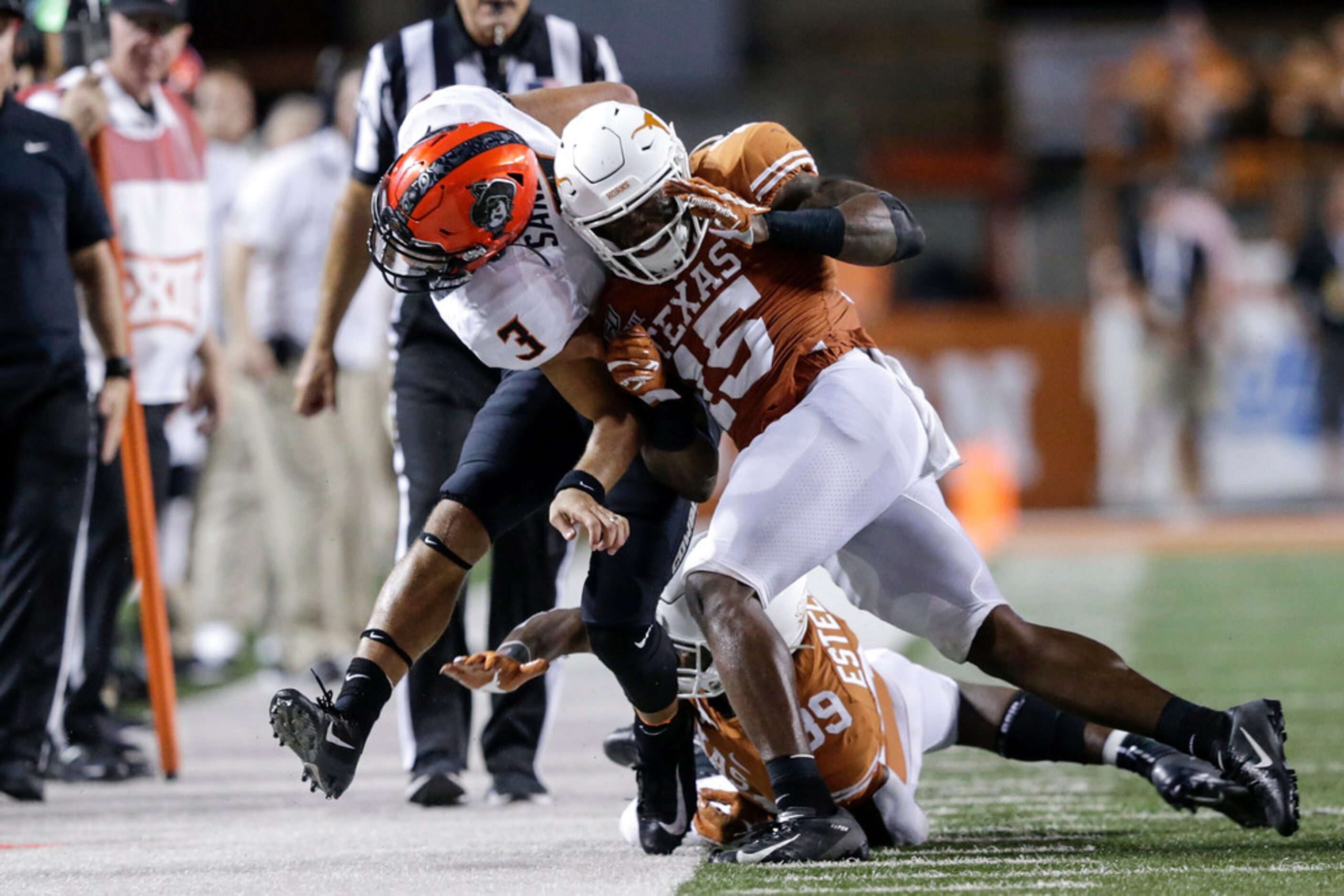 AUSTIN, TX - SEPTEMBER 21:  Chris Brown #15 of the Texas Longhorns tackles Spencer Sanders...