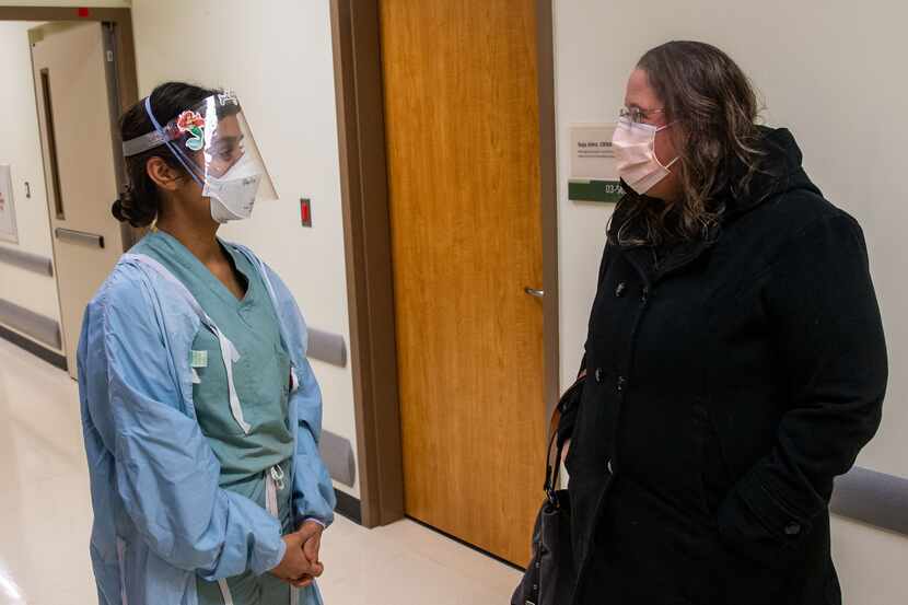 Perla Sanchez-Perez, left, briefs Samantha Rowley, senior vice president of nursing for...