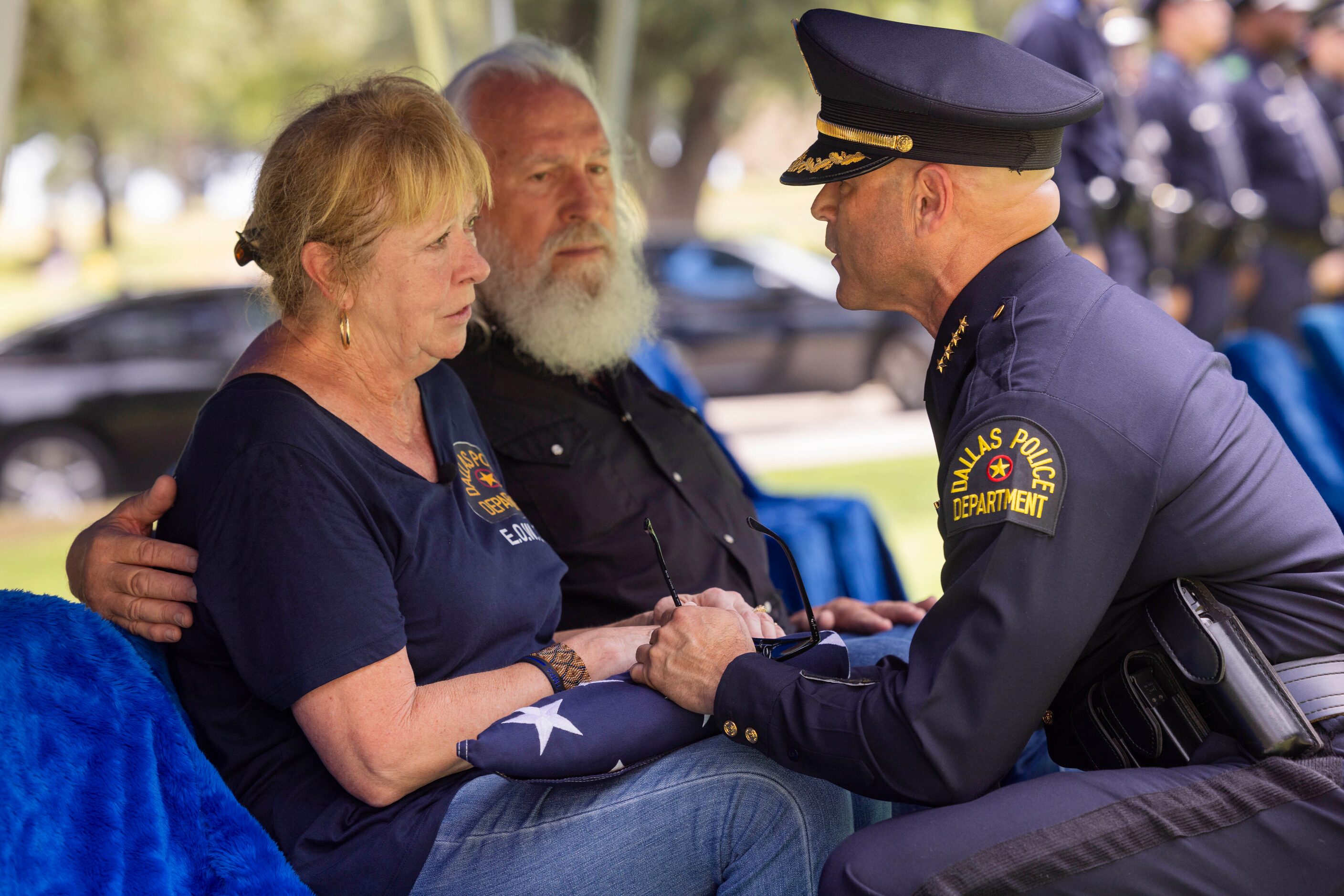 Dallas police Chief Eddie García presents a folded flag to Kimberly Black, daughter of Sgt....