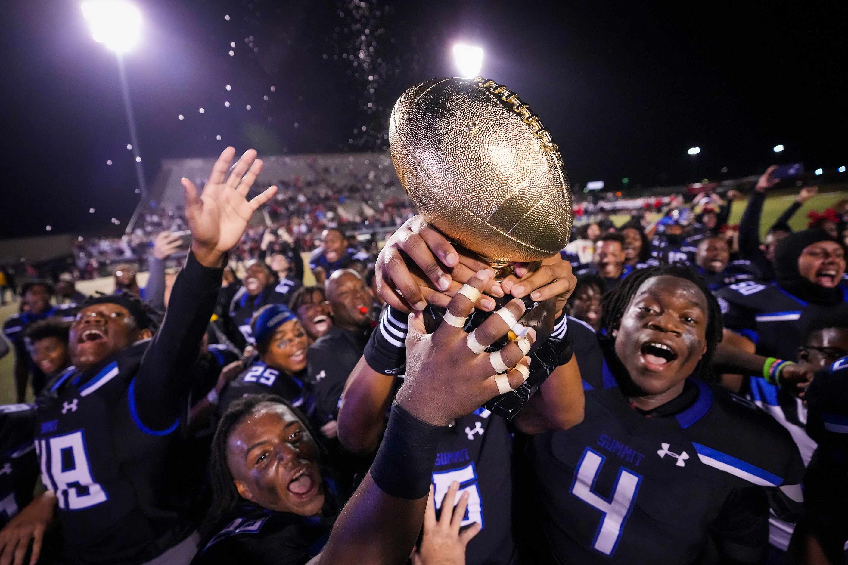 Mansfield Summit players celebrate with the game trophy after a victory over Colleyville...