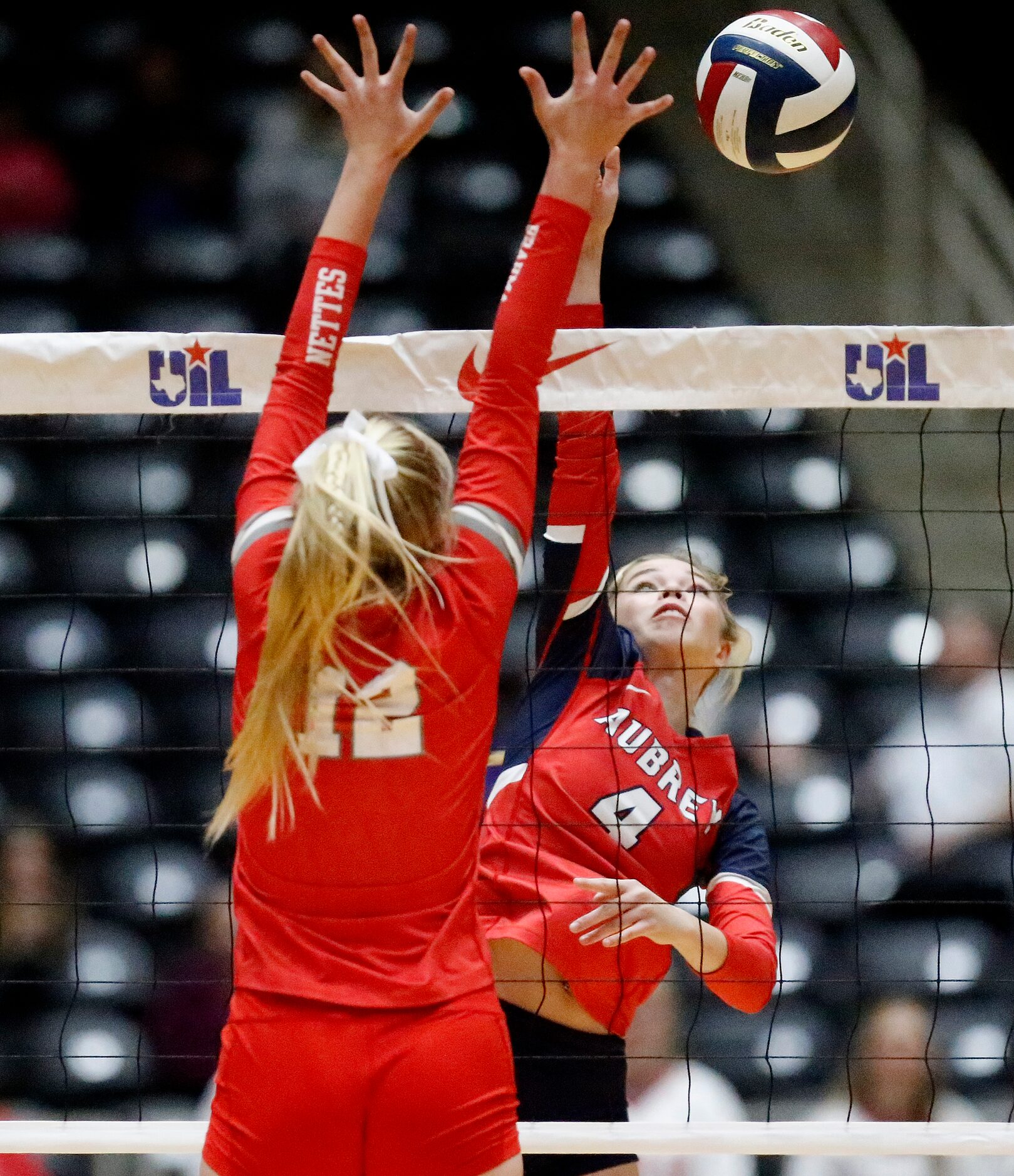 Aubrey High School’s Abby Wright (4) gets a hit as Bellville High School’s Marin...