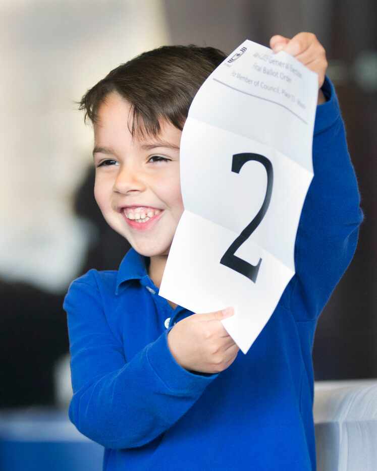 George Villalba, 5, son of Dallas mayoral candidate, Jason Villalba, holds the number his...