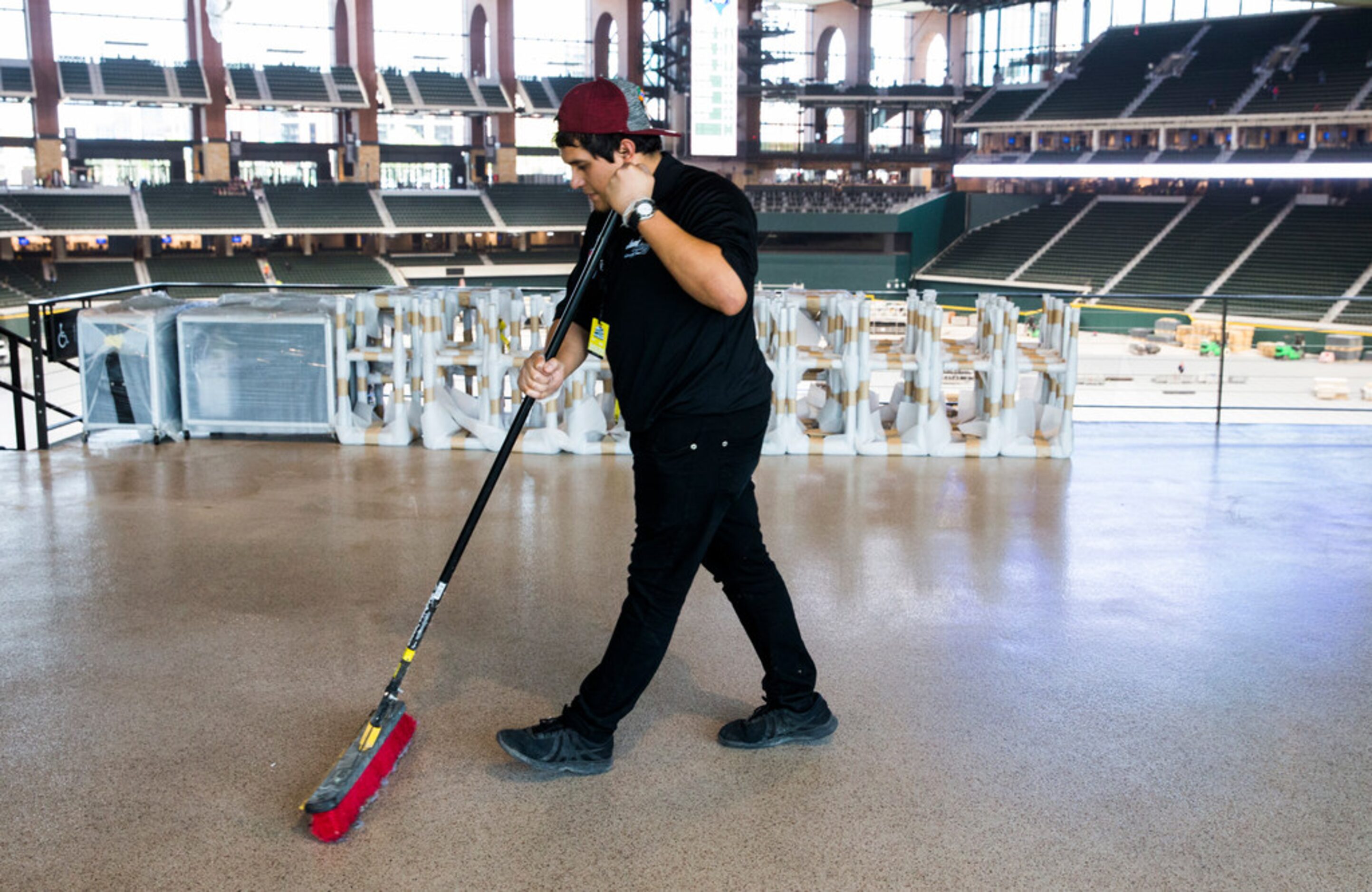 Luis Perez sweeps the main concourse during an open house for the Texas Rangers' new Globe...