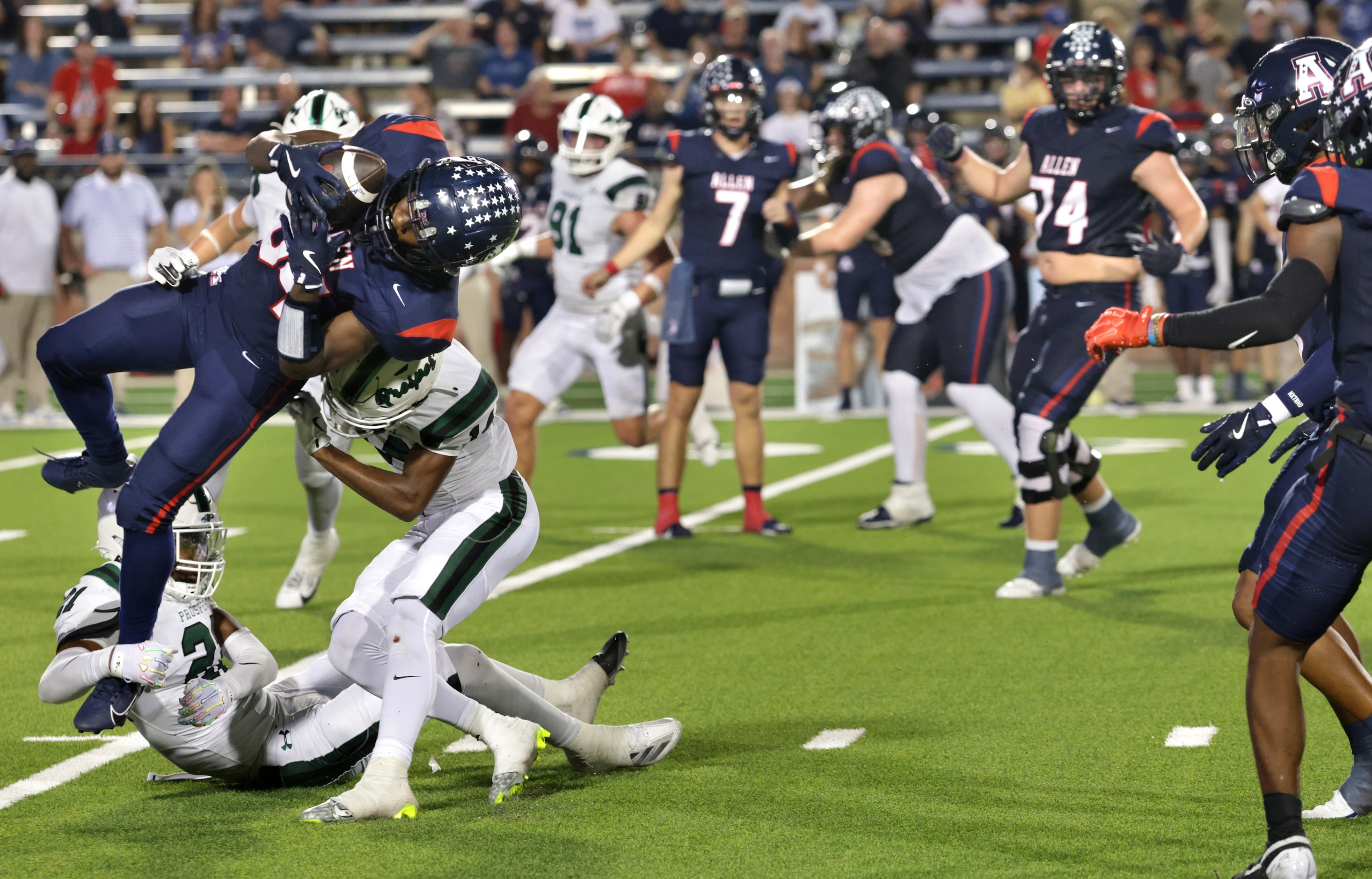 Allen player #84 Josyah Johnson gets tackled by Prosper players #21 DK Jamison and #14 Vance...