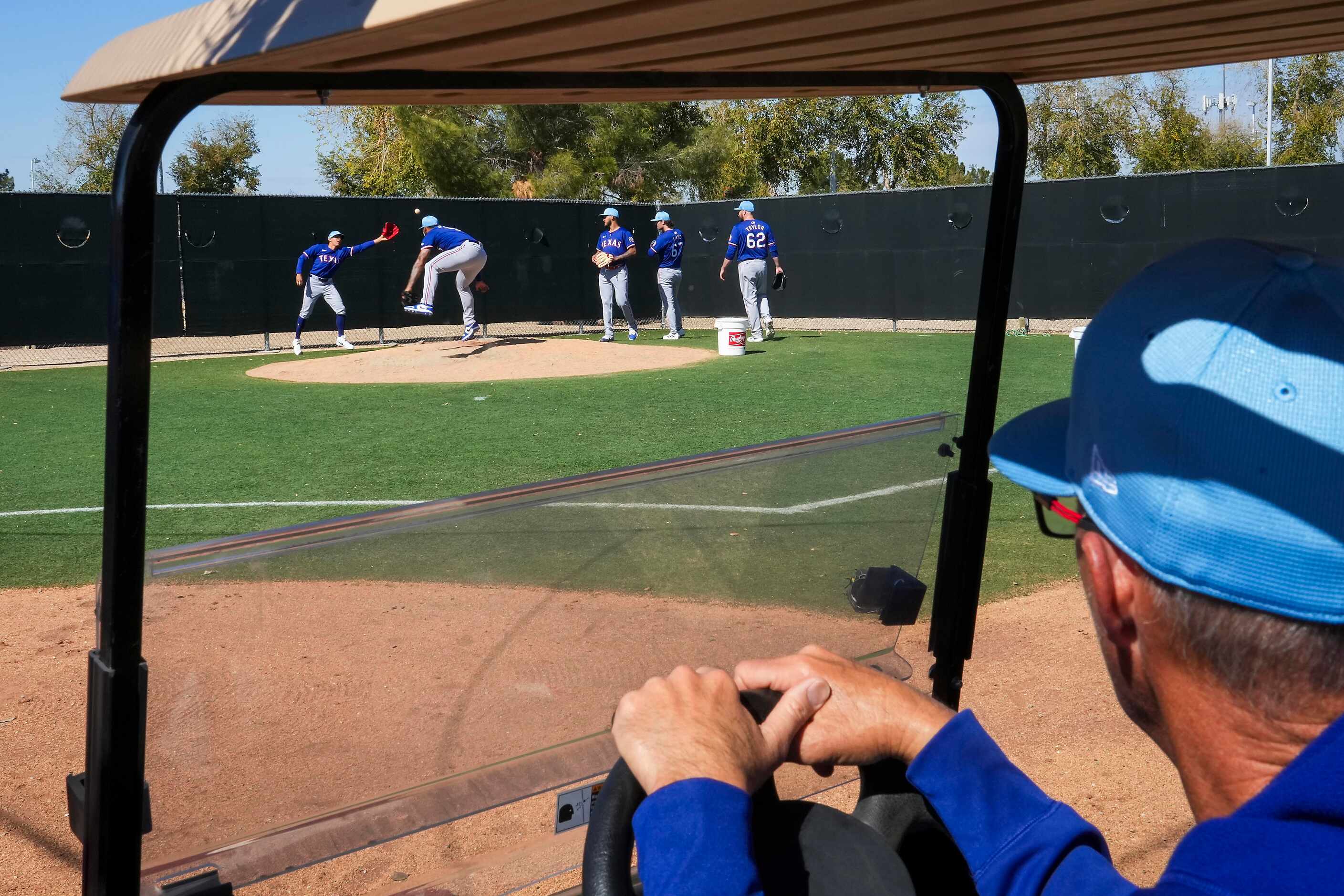 Texas Rangers pitching coach Mike Maddux watches from a golf cart as pitcher Jesús Tinoco...