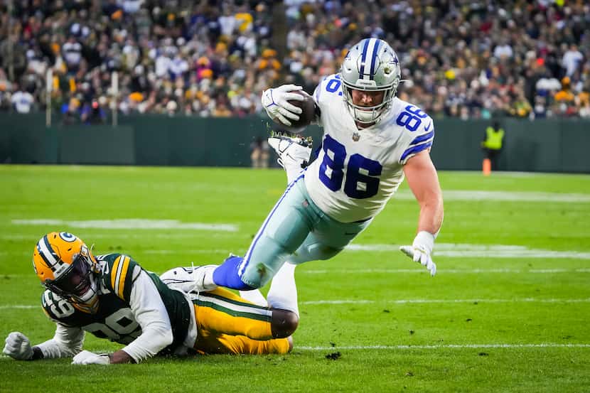 Dallas Cowboys tight end Dalton Schultz (86) is tripped up by Green Bay Packers cornerback...