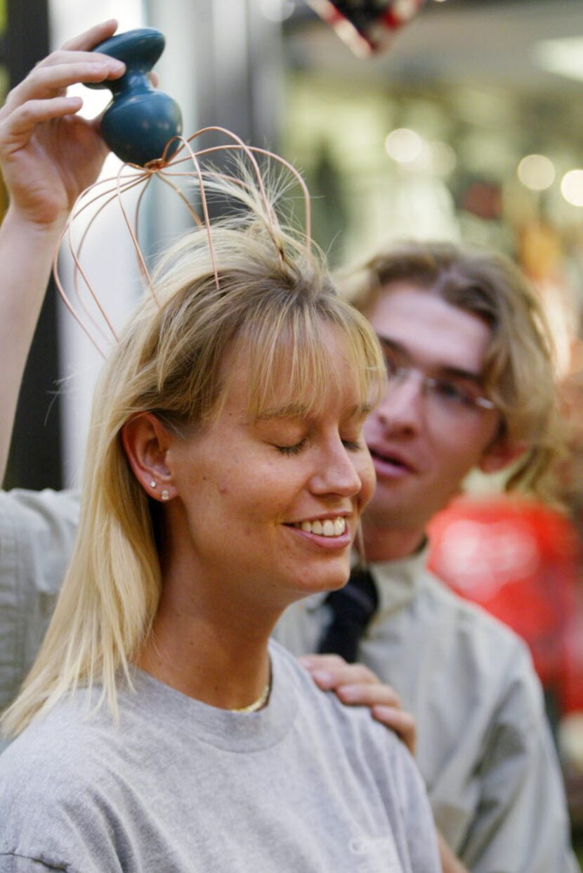 Photo shot 12/5/03 -- Eli Riskin, an employee of the Ultimate Massager Kiosk in Collin Creek...