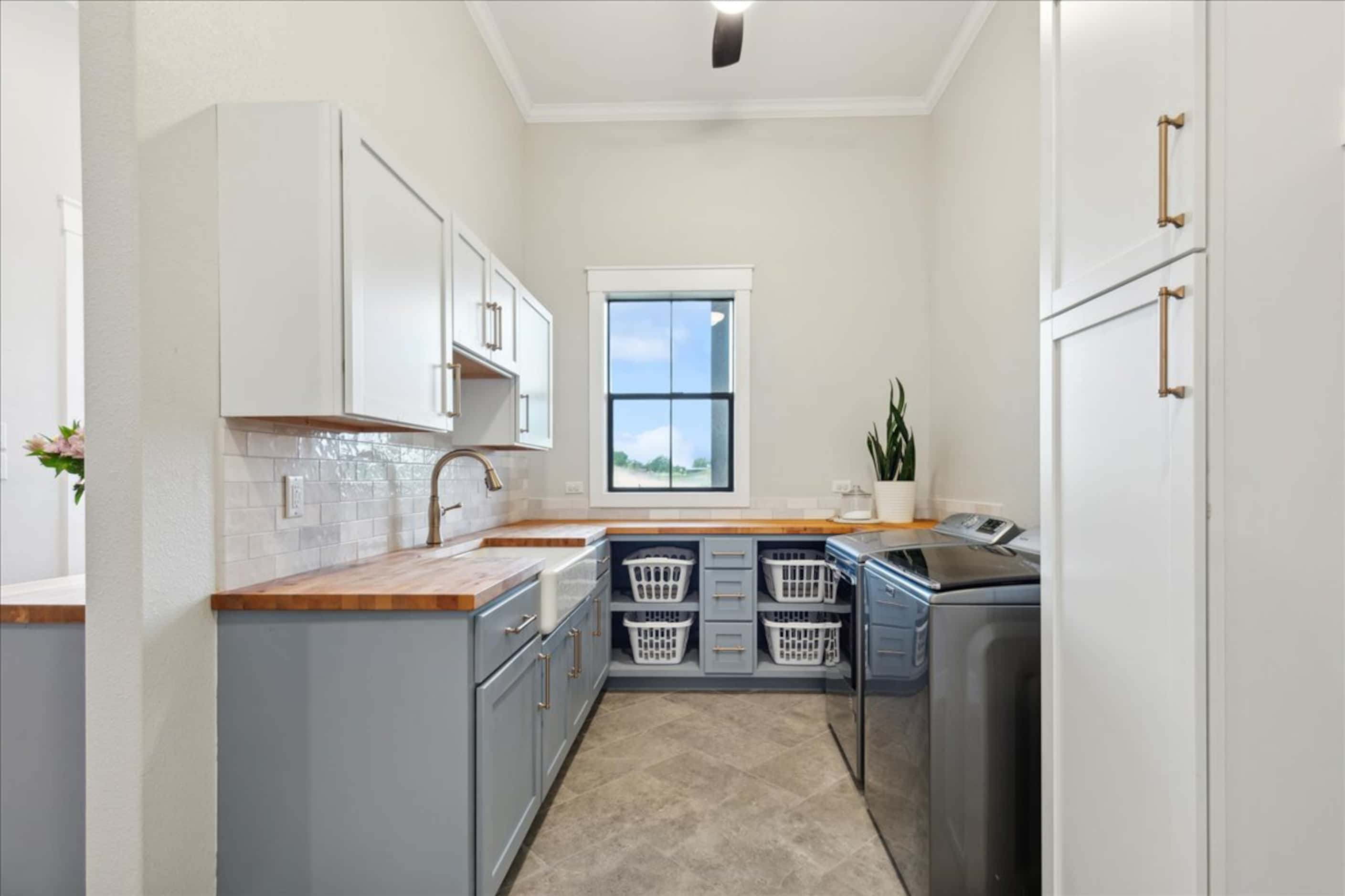 Laundry room with gray and white cabinetry