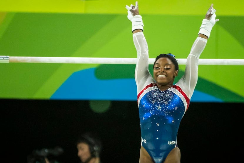 Simone Biles of the United States competes on the uneven bars during the women's gymnastics...