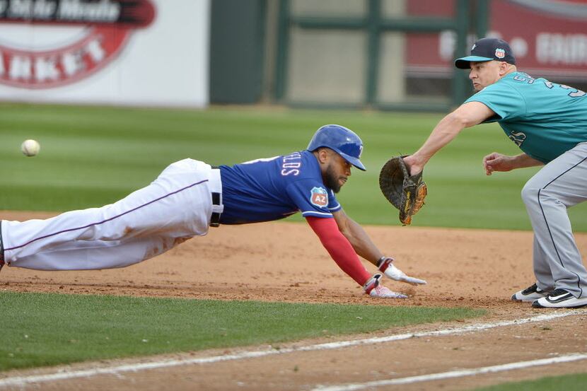 Texas Rangers center fielder Delino DeShields (3) gets brushed back to first base as Seattle...