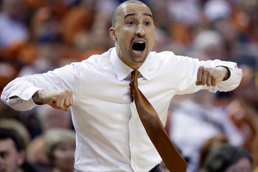 Texas coach Shaka Smart talks to his players during the first half on an NCAA college...