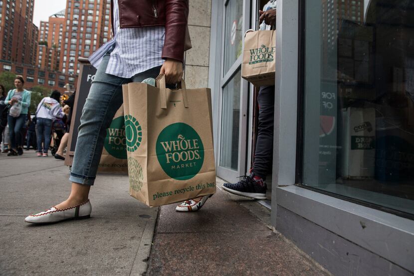 Customers walk out of Whole Foods in New York, June 16, 2017. (Todd Heisler/The New York Times)