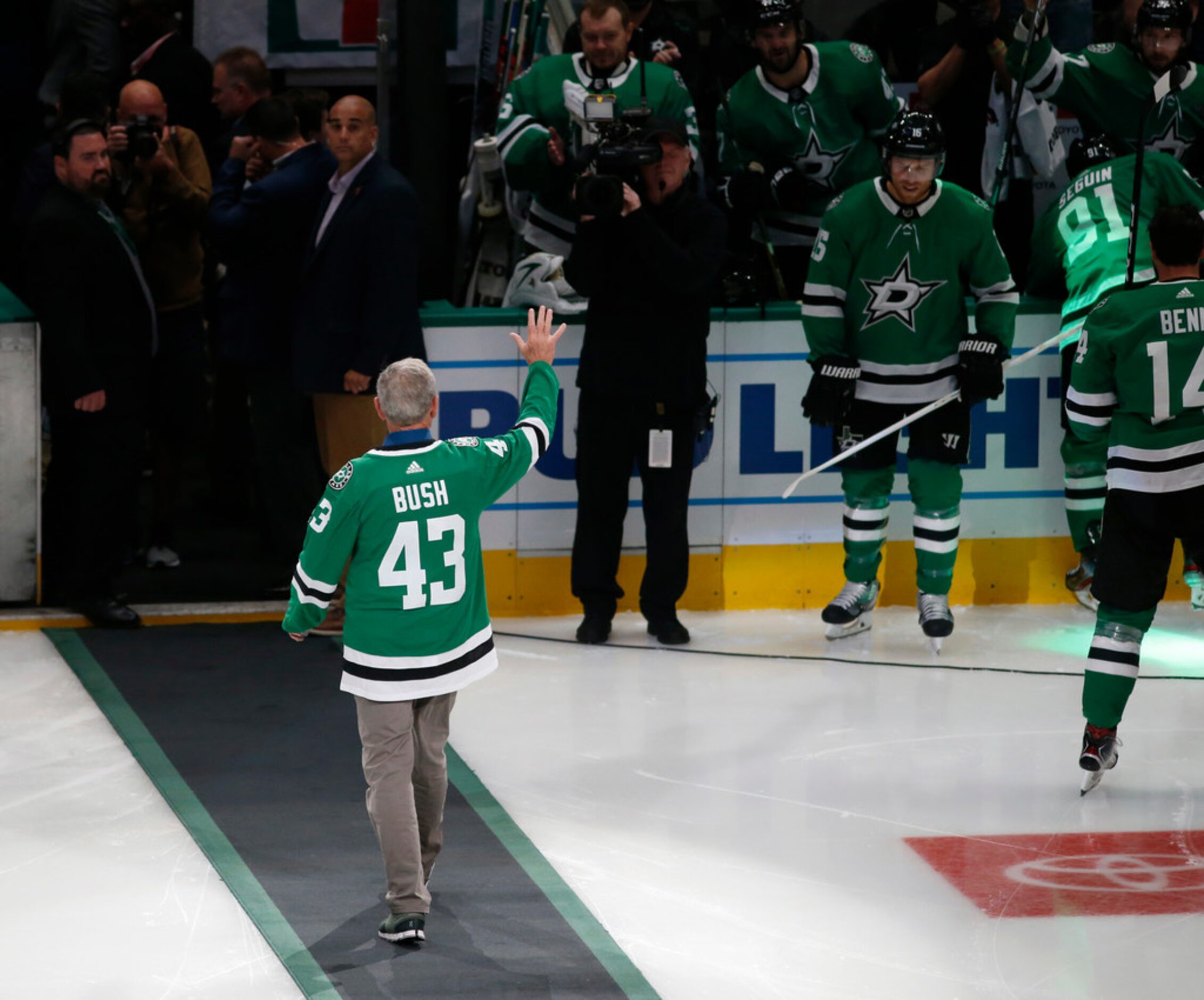 Former President George W. Bush waves to the fans after dropping the puck before a game...