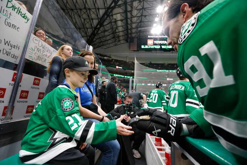 Carson Beaulne, 6, of Ottawa received a puck from Dallas Stars center Tyler Seguin (91)...